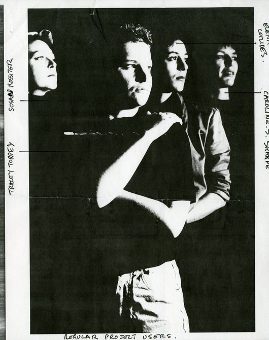 A scan of a Open Secrets poster with the cast looking away to the right..