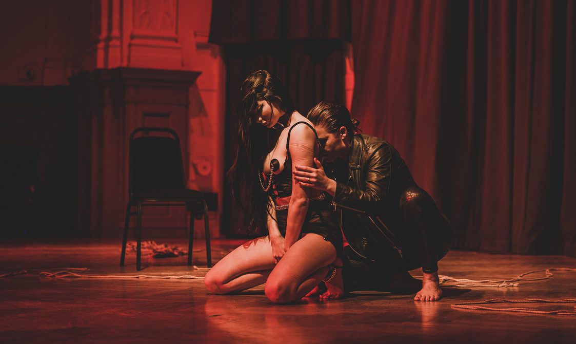 Anna Bones and Sweet Severine performing in a red lit Great Hall