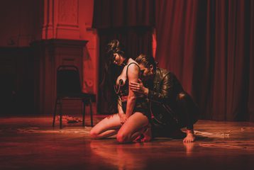 Anna Bones and Sweet Severine performing in a red lit Great Hall