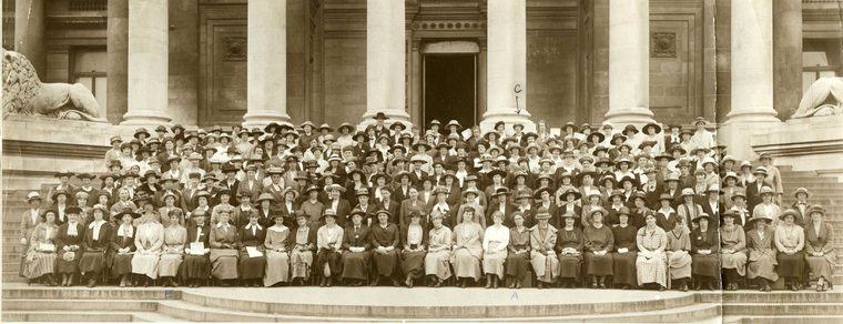 Black and white image of Agnes Dawson and a large group outside a building for a National Union of Women Teachers conference. The building has pillars and lion statues at the entrance.