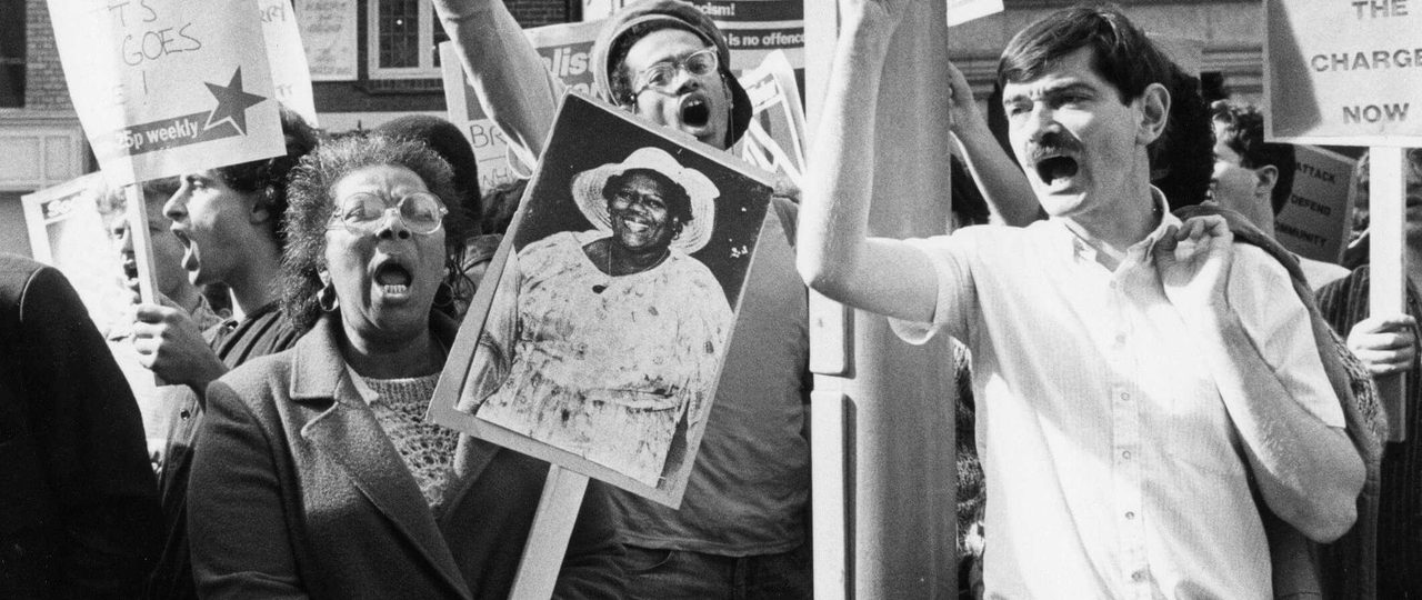 A black and white photo from the protest and campaigning archives. Protestors are holding signs which say: "Black and White, unite and fight", and "Socialist Worker".