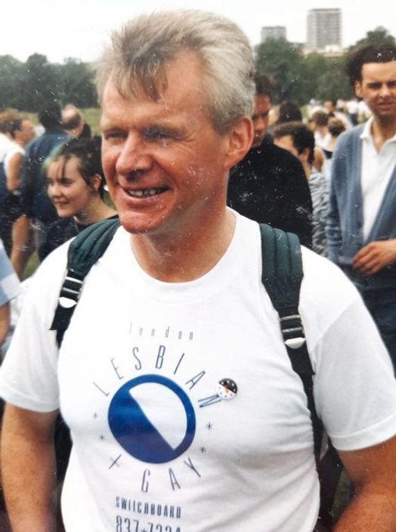 A photograph of Bob Cant at 1988 Pride. He is wearing a top that says "Lesbian Gay", and has a rucksack on. A group of people are standing behind him.