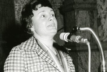 Black-and-white photograph of Christine Walker speaking at an event