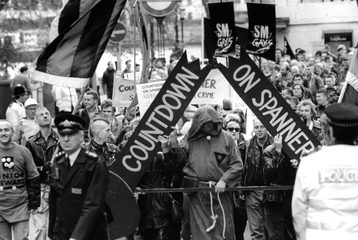 SM Pride March on 28 November 1992. Protestors are holding a banner that says "Countdown on spanner" with a police officer ahead of the protestors.