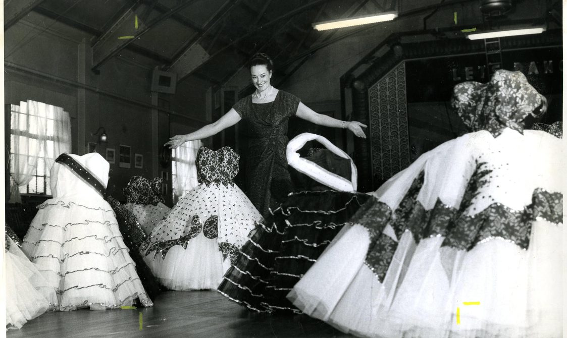 Four dresses are being displayed in this black and white images, with puffy white skirts and white and black bodices.