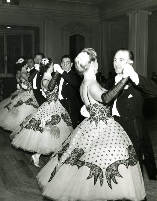A black and white photograph of the original Penge team performing. Three women are dancing with three men in hold.