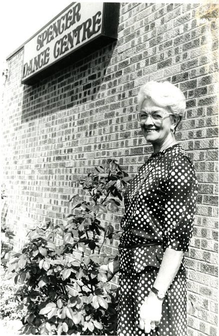 Peggy Spencer standing next to a sign that says: "Spencer Dance Centre".