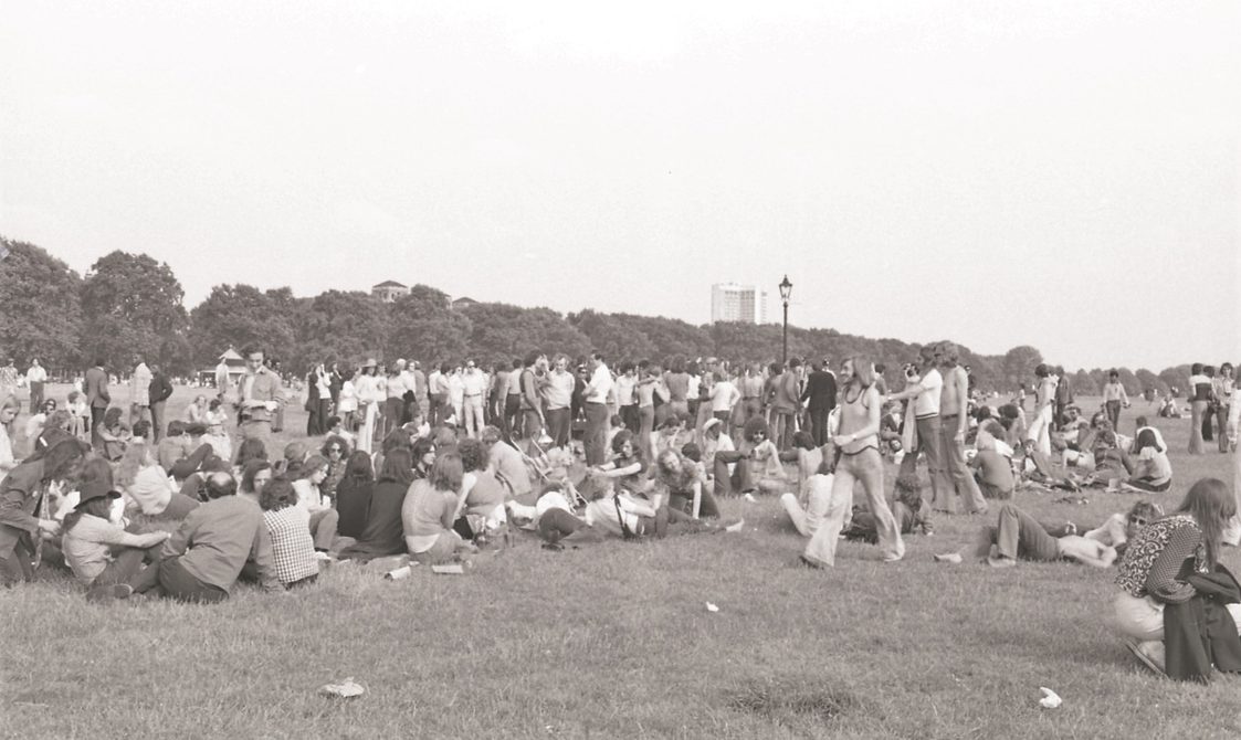 A picture from the second Pride march in 1973. A group of people are sitting in Hyde Park.