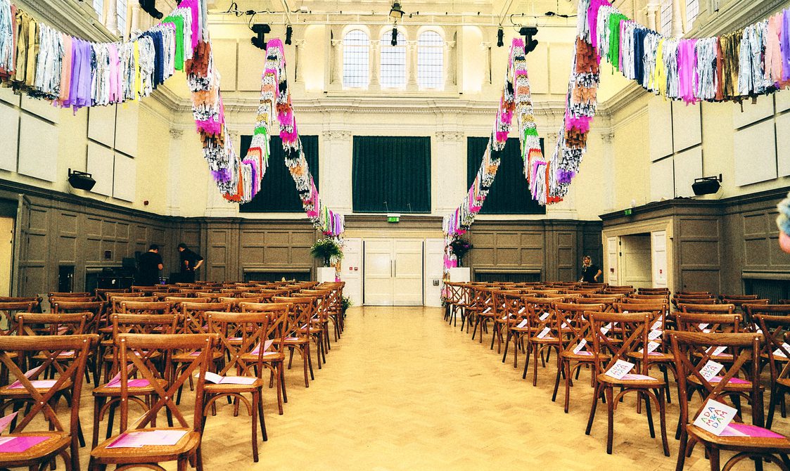 The Great Hall decorated with streamers, with seats laid out for a wedding.