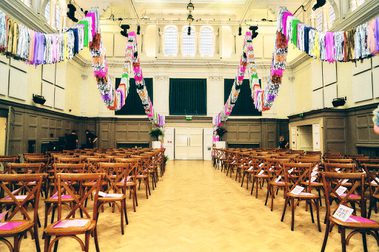 The Great Hall decorated with streamers, with seats laid out for a wedding.