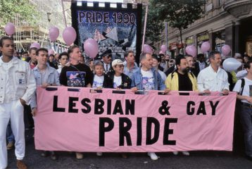 People carrying the lead banner of the Lesbian & Gay Pride parade from 1990, at the front of the march.