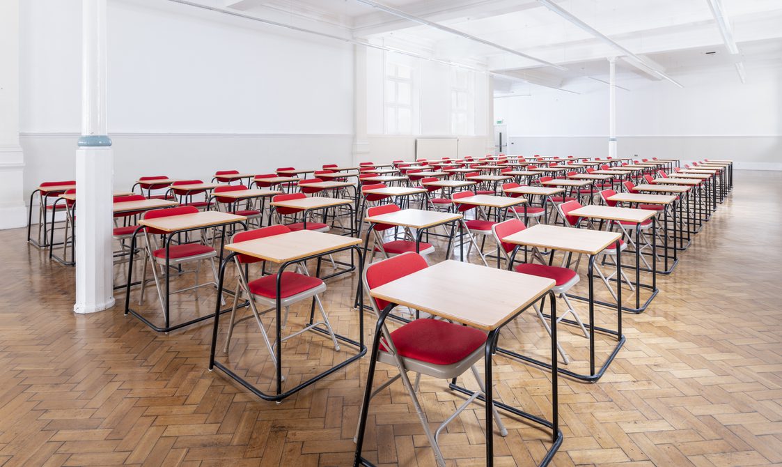 Rows of single tables with chairs are laid out in Bishopsgate Institute's Upper Hall in an examinations style.