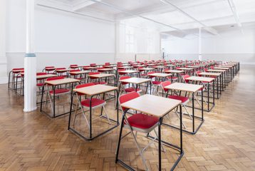 Rows of single tables with chairs are laid out in Bishopsgate Institute's Upper Hall in an examinations style.