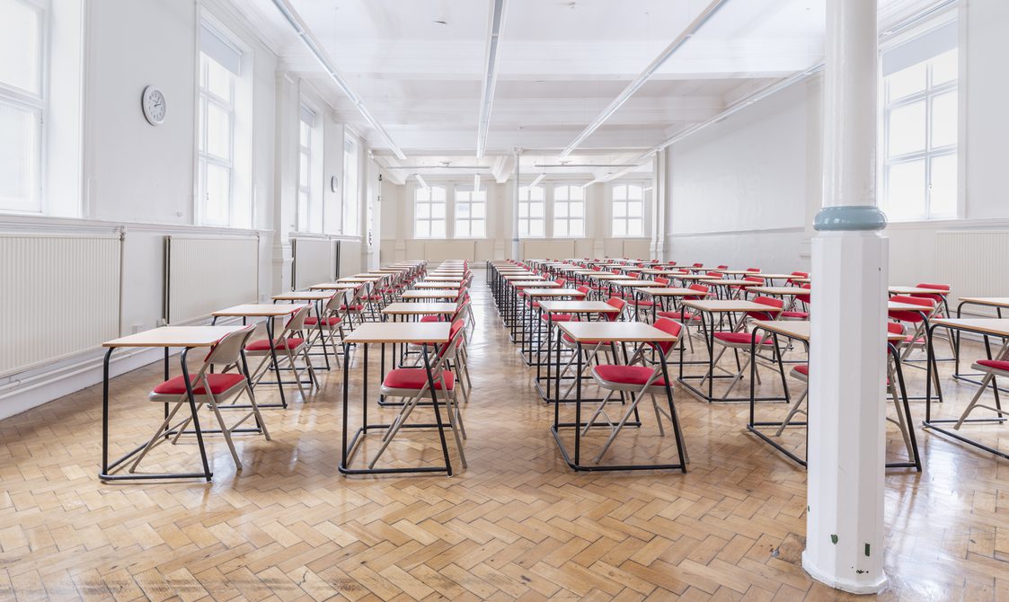 A photograph of Bishopsgate Institute's Upper Hall with single tables lined up with chairs, done in an exam-style layout.