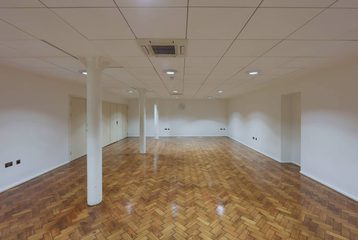 Bishopsgate Institute's Goss Room. The floor is laminate, with white walls and white beams to the left of the room.