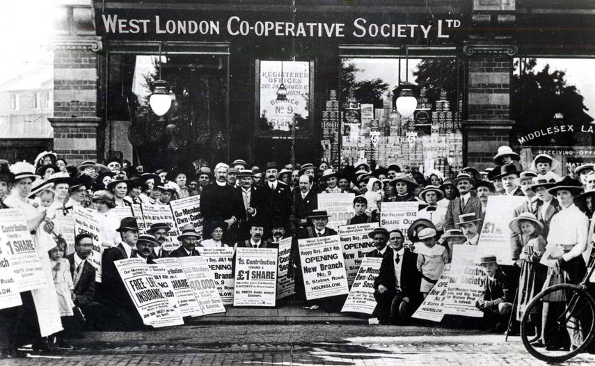 Black and white image of people standing in front of the West London Co-operative Society with signs