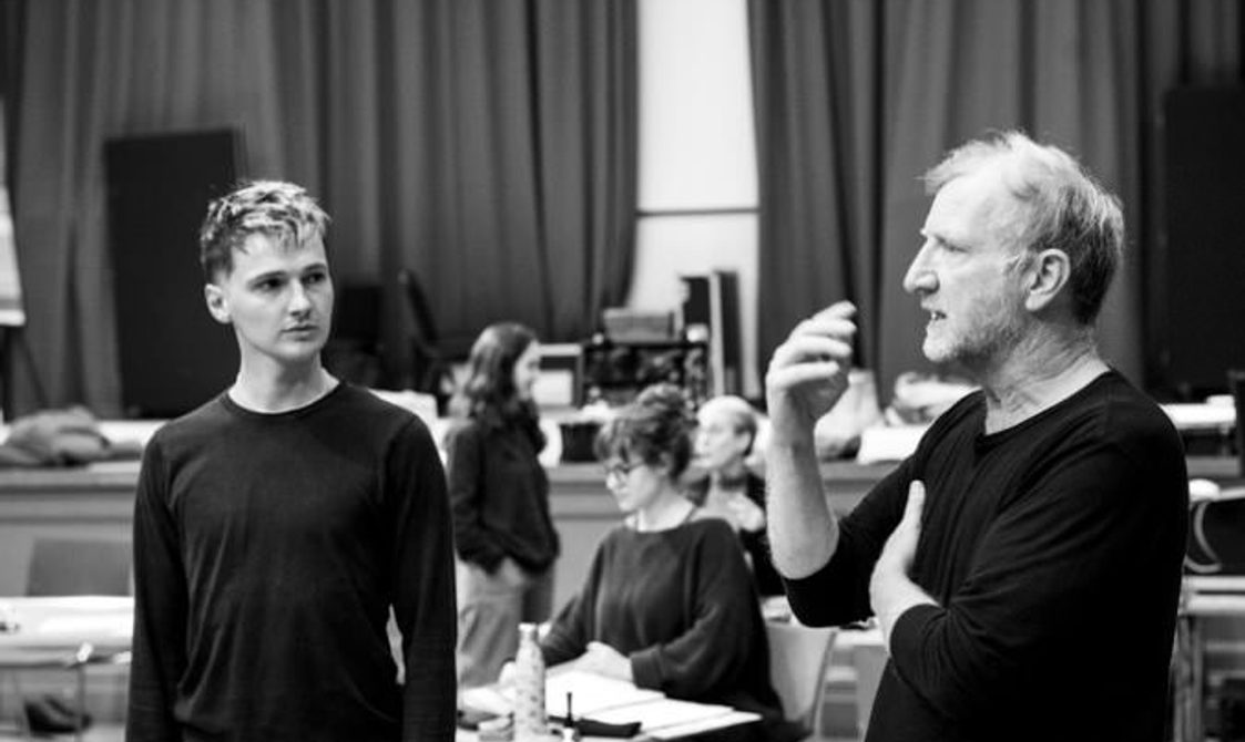 Two actors in discussion in the Great Hall.