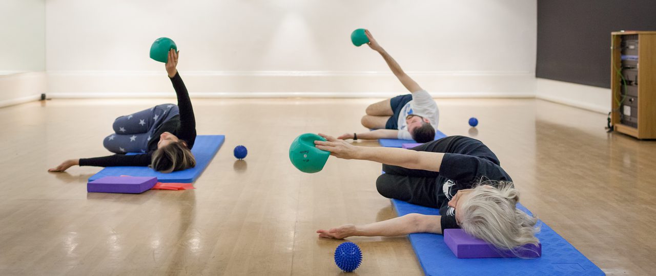 a group taking a Pilates class at Bishopsgate Institute, London