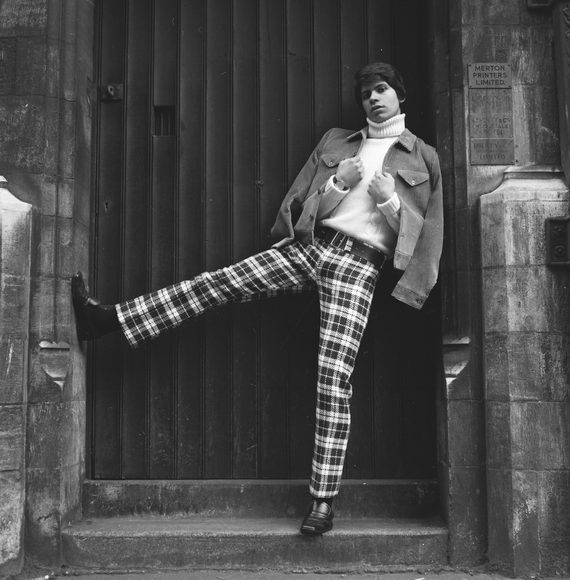 A Black and white photo of a male model posing in a church doorway in the 1960s