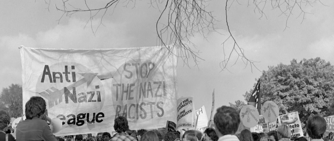 Image from the Robert Workman Archive. Crowd walking in protest holding banner which reads "Anti Nazi League" and "Stop the Nazi racists".