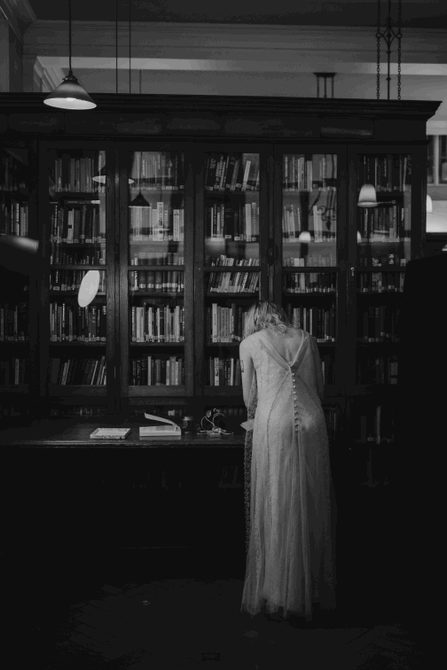 An individual, with their back turned, signs a document in our Library.